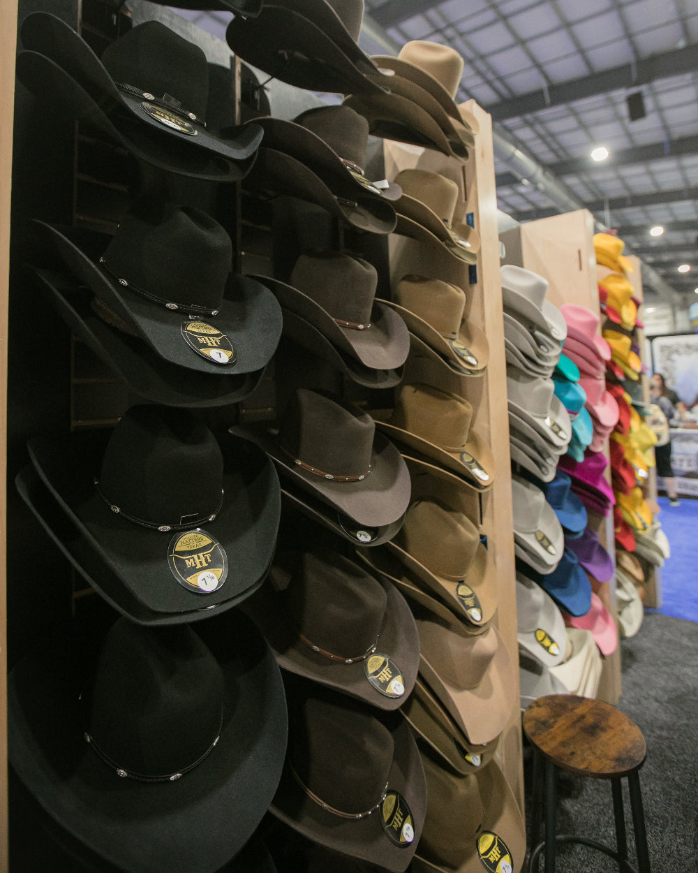 Display of wild pony hat bar cowboy hats in various colors on a stand.