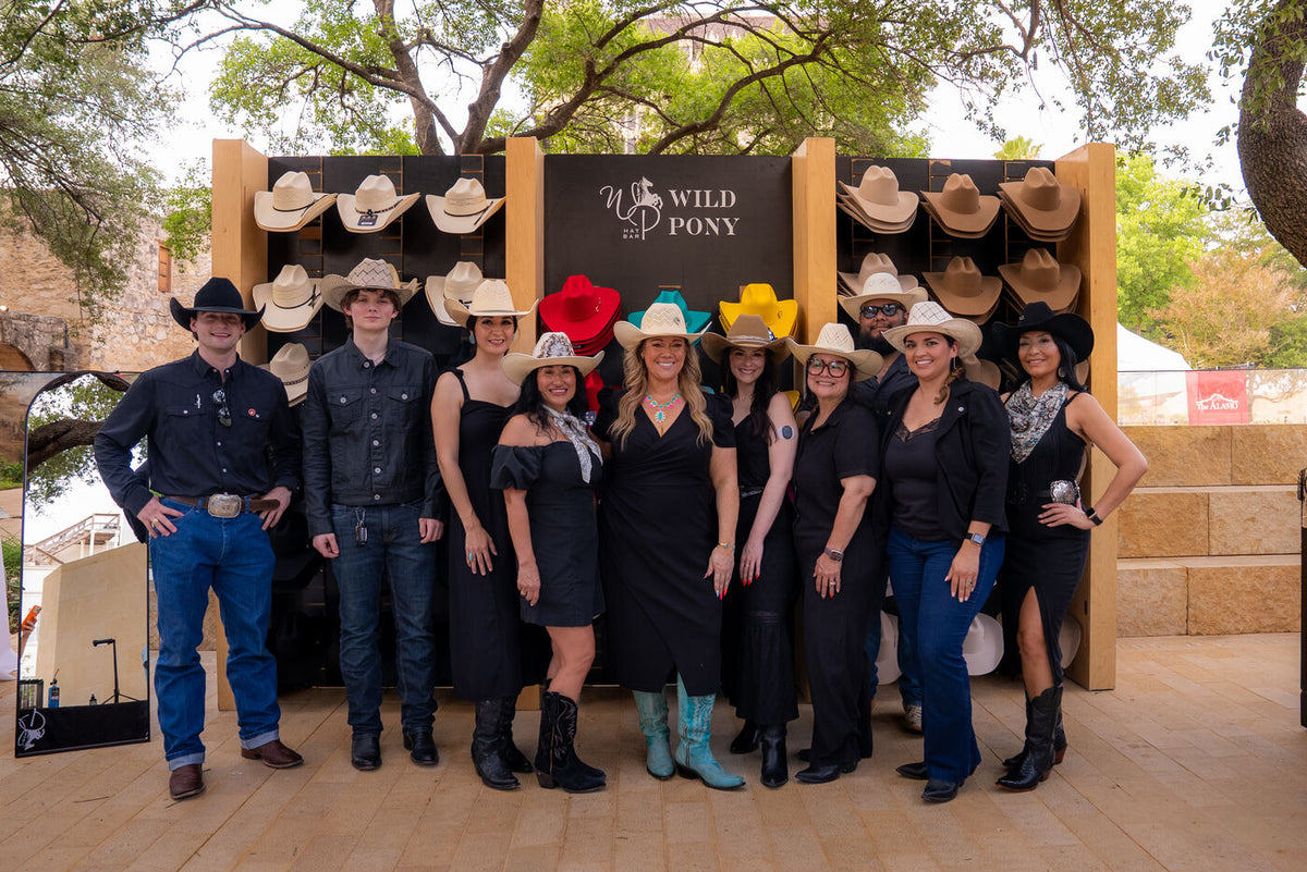 The Wild Pony Hat Bar team in front of their mobile hat wall at an event