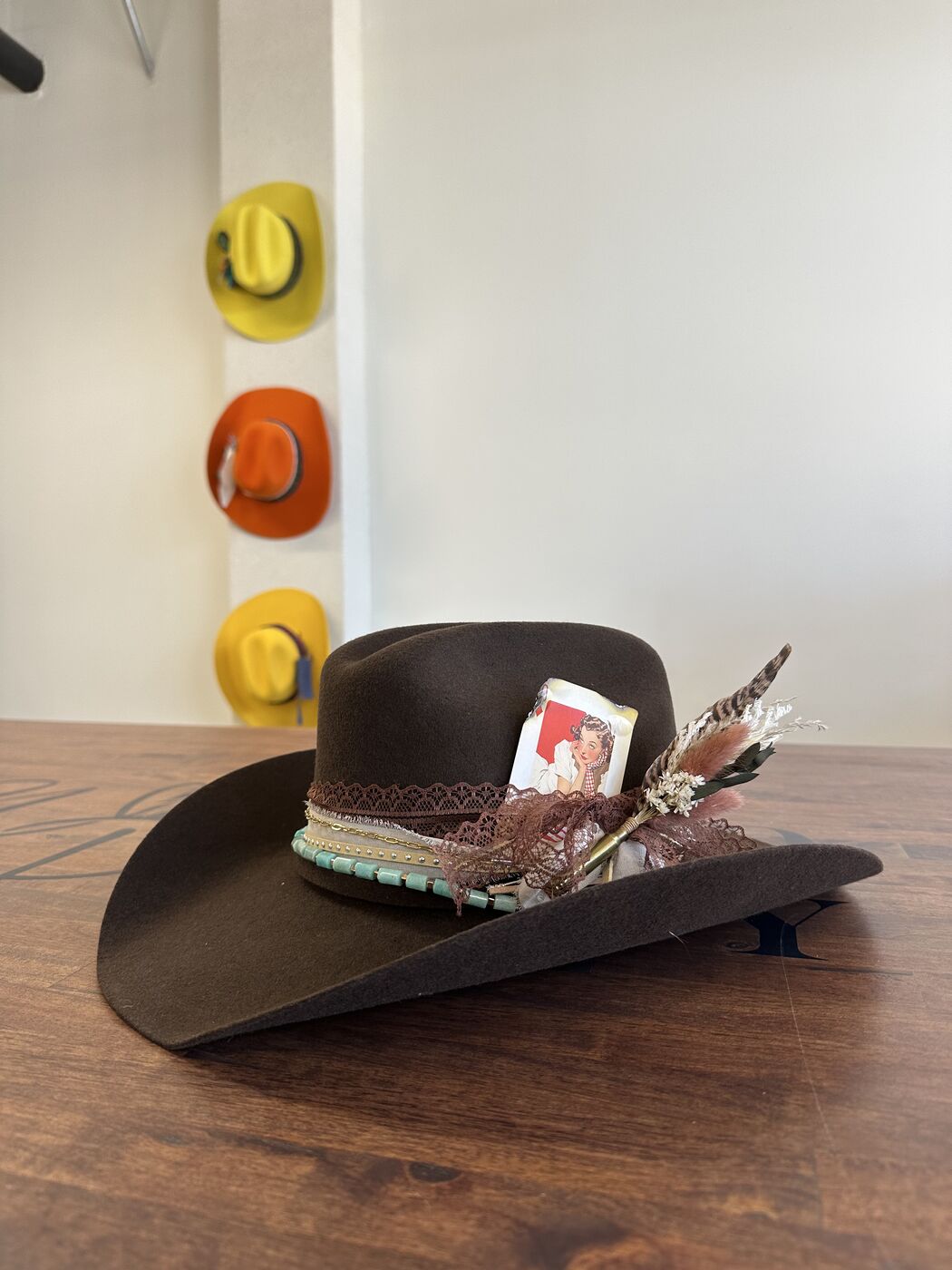Custom brown felt cowboy hat with feathers and a beaded band