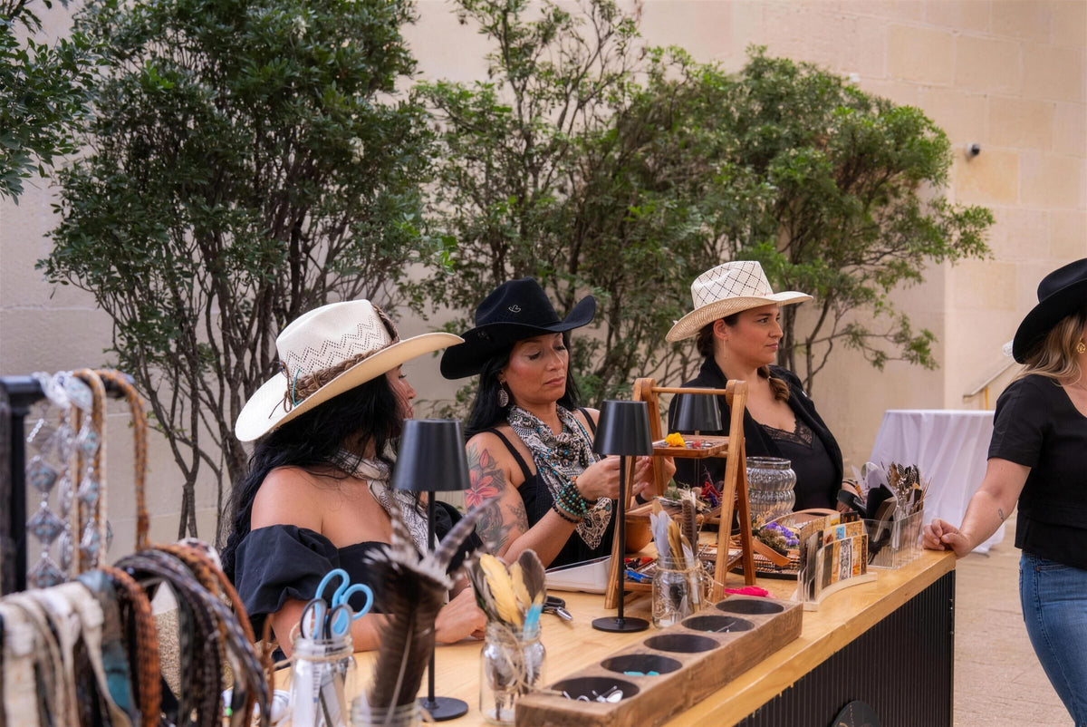 Wild Pony stylists at an outdoor event booth helping guests customize hats